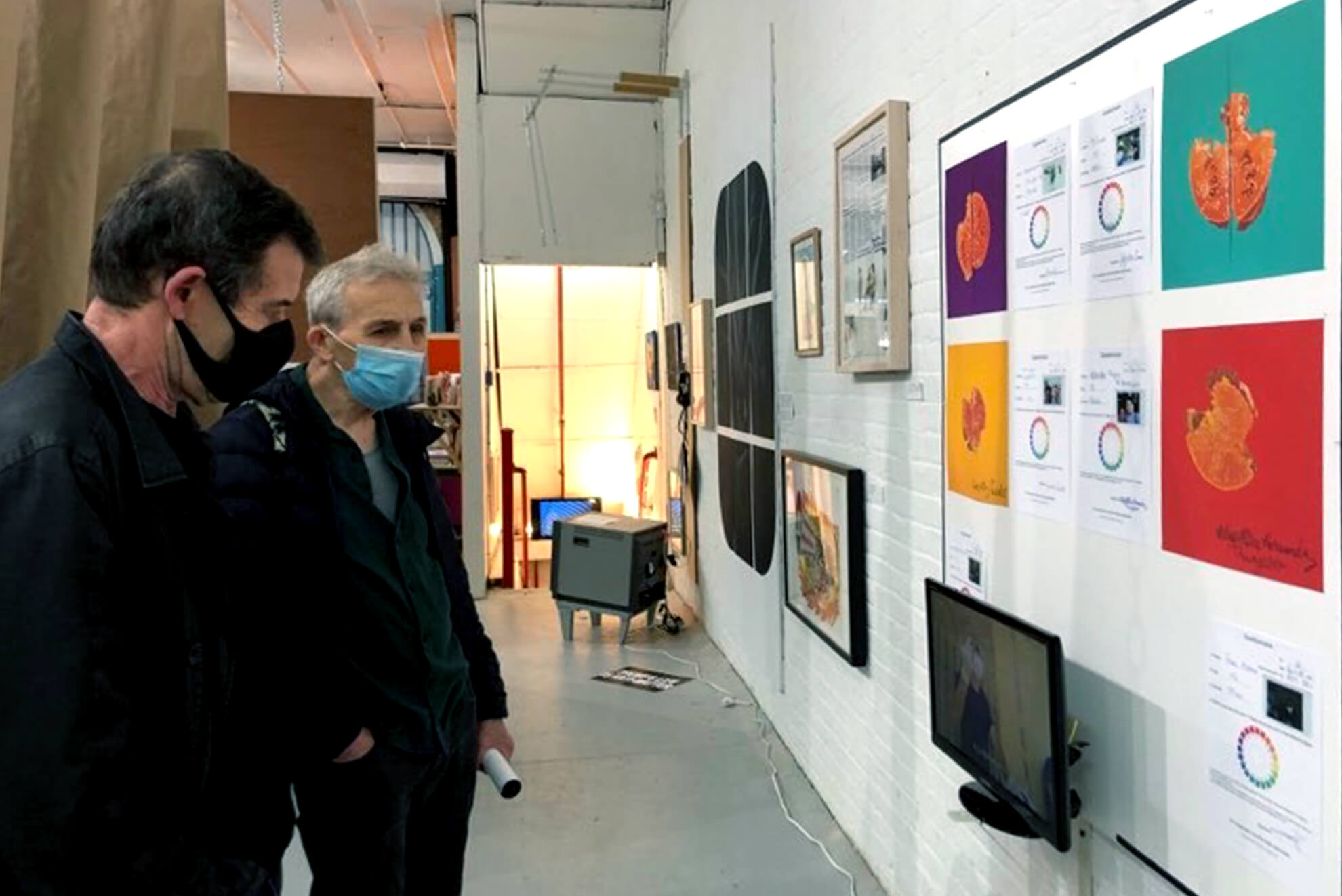 Image of Fluxus Jeffrey and Emily Harvey Foundation director looking at the work of a project where Shintaku bites a hamburger with a homeless in LA